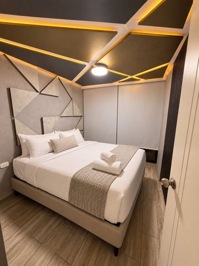 Penthouse Suite San Isidro — Dormitorio principal con cama queen y techo de luz cálida