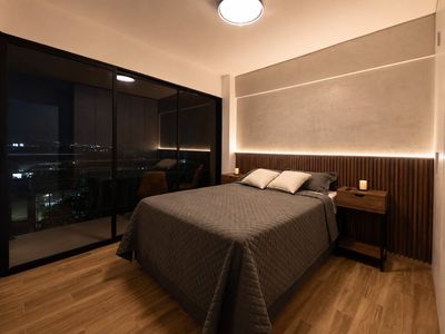Suite Ejecutiva — Dormitorio principal, con ventanal a la ciudad