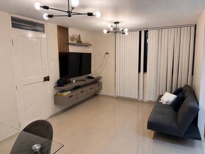 Suite Mochica — Sala con sofá cama y televisor