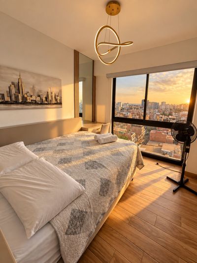 Sunset Suite — Dormitorio con ventanal a la ciudad